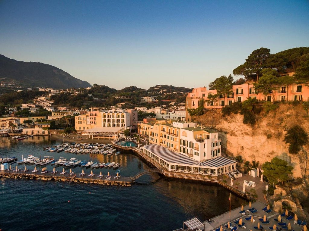 Elegant cliffside hotel Regina Isabella in Ischia, with Mediterranean-style terraces, palm trees and panoramic views of turquoise waters