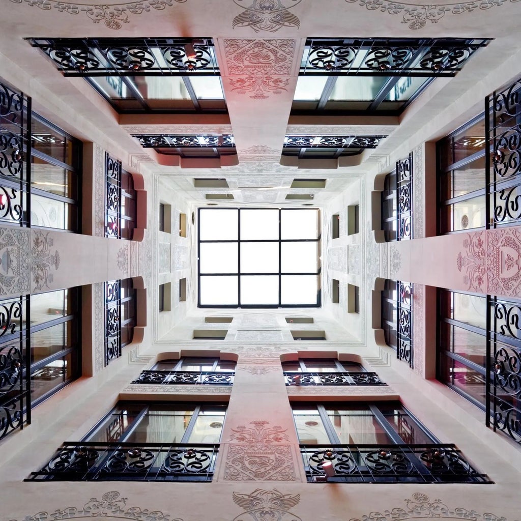 Elegant Spanish hotel facade with ornate architectural details, wrought-iron balconies, and warm terracotta tones in Barcelona's historic city center