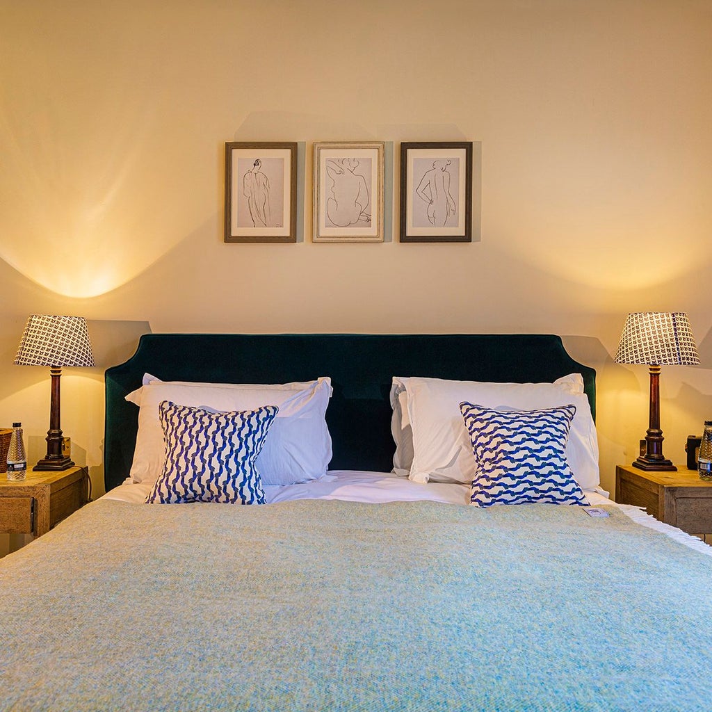 Elegantly appointed deluxe suite at a historic UK hotel, featuring plush king bed, rich wooden furnishings, and refined neutral color palette with soft accent lighting