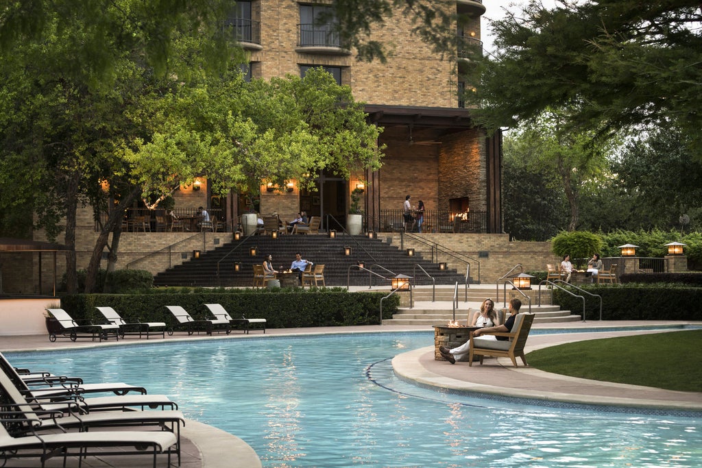 Elegant Four Seasons Dallas luxury resort with curved marble driveway, manicured gardens, white stone facade and towering palm trees