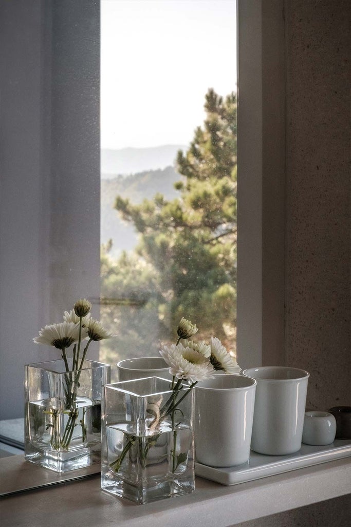 Elegant Portuguese alpine hotel room with rustic wooden walls, minimalist design, and panoramic mountain view through large window at Casa de São Lourenço