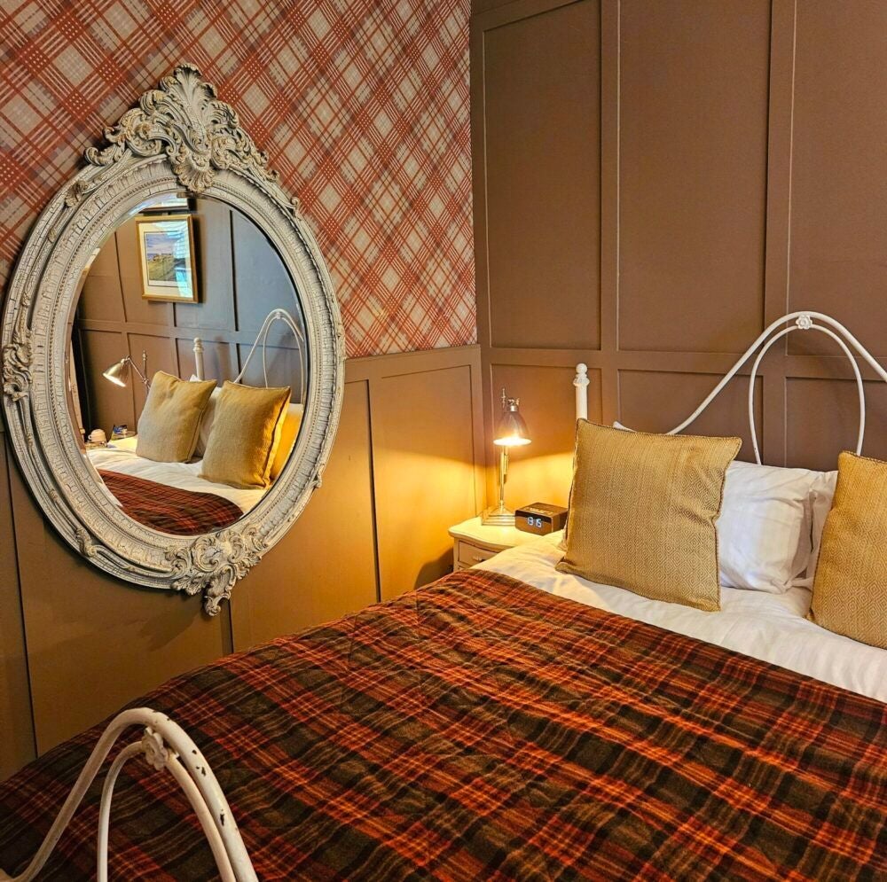 Elegant seaside hotel room with coastal-inspired decor, plush white bedding, and panoramic views of the Scottish coastline at Scenset Manor