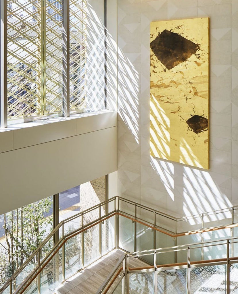 Elegant Kitano Hotel exterior in Japan features modern glass facade, luxurious entrance with stone columns and manicured landscaping