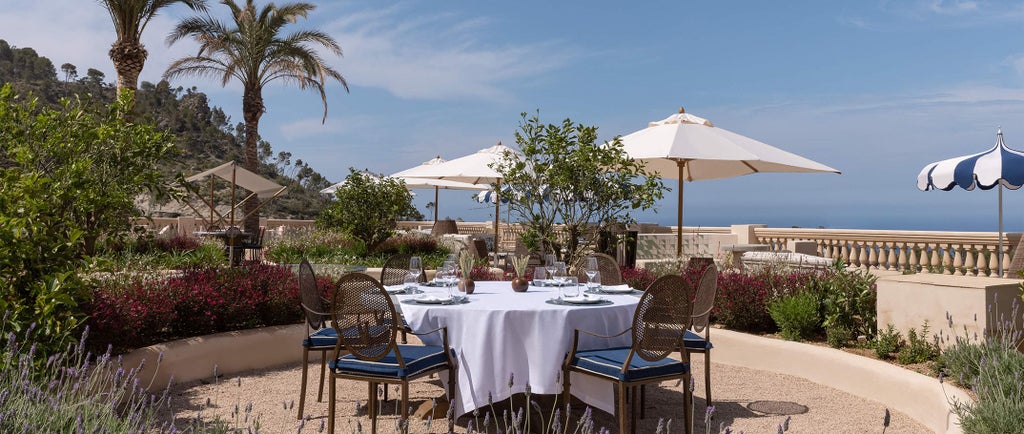 Luxury hotel Son Bunyola in Mallorca features a grand stone building with terracotta roof, nestled amid lush Mediterranean gardens