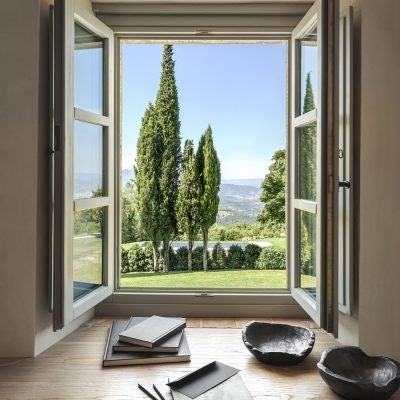 Elegant Tuscan hotel room with sweeping vineyard views, rustic wooden furniture, crisp white linens, and warm terracotta-toned walls in traditional Italian style