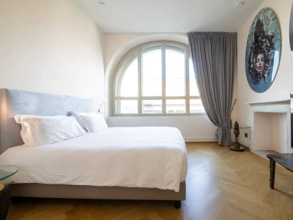 Luxurious presidential suite with panoramic city views, elegant Italian design, plush king bed, and modern art against expansive Milan skyline backdrop