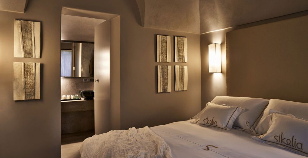 Luxurious master suite with elegant white décor, minimalist design, plush bedding, and panoramic windows overlooking scenic Sicilian landscape at Sikelia hotel