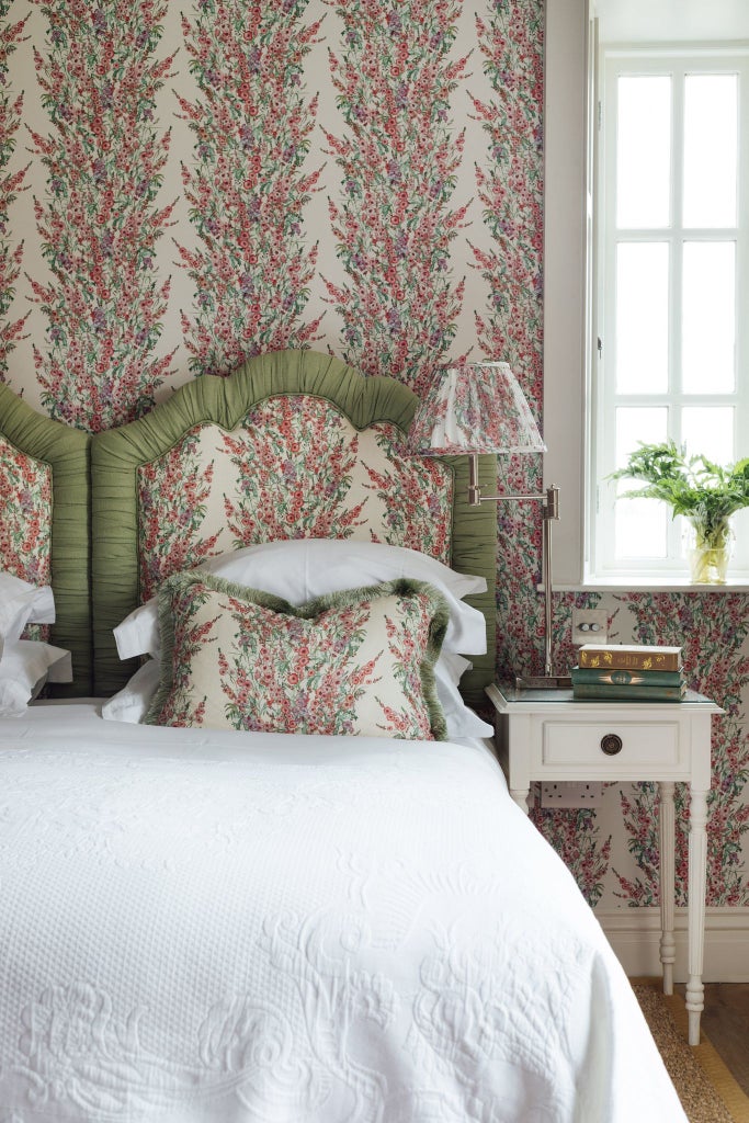 Luxurious hotel bedroom with crisp white linens, plush throw pillows, elegant wooden headboard, and soft ambient lighting in tranquil neutral tones