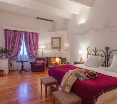 Rustic luxury Argentine deluxe room with wooden furnishings, soft white linens, and elegant traditional decor overlooking scenic mountain landscape