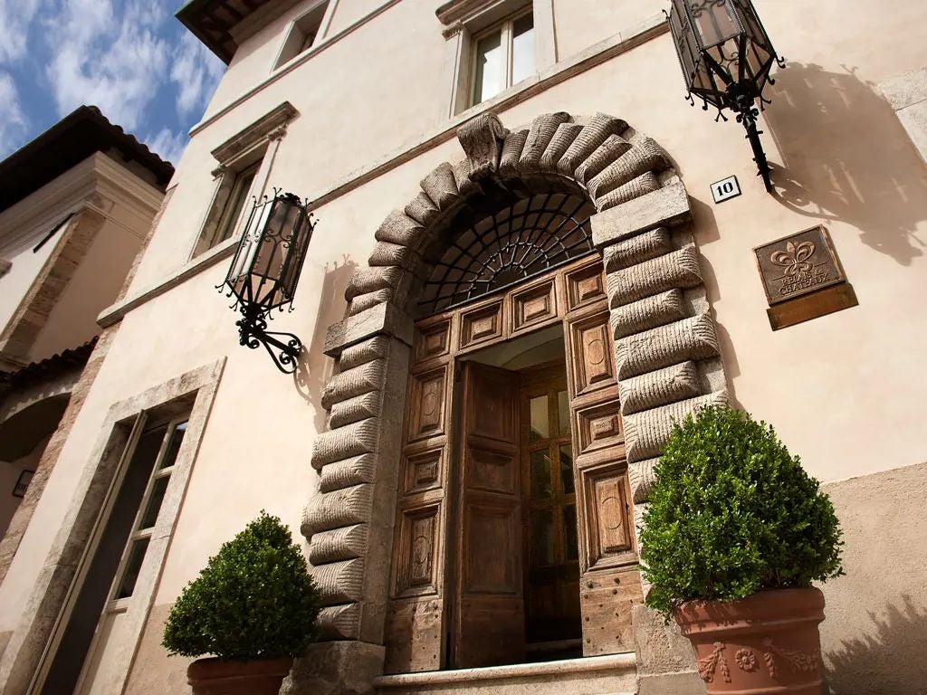 Elegant stone facade of historic Palazzo Seneca hotel in Norcia, showcasing Renaissance architecture with warm stone walls and classic Italian design