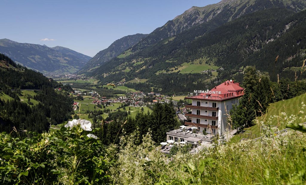 Elegant Austrian boutique hotel with modern glass facades nestled in snowy Alps, featuring luxurious balconies and mountain vistas