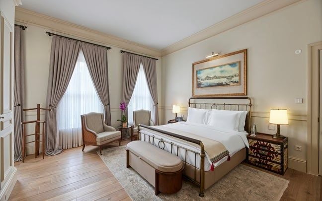 Elegant deluxe king room at scenset Kocatas Mansions, featuring luxurious Turkish decor, rich wooden furnishings, and soft ambient lighting