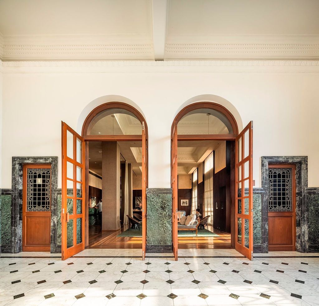 Elegant Fasano hotel facade in Salvador, Brazil, with colonial architecture, white walls, classic balconies, and lush tropical landscaping at dusk