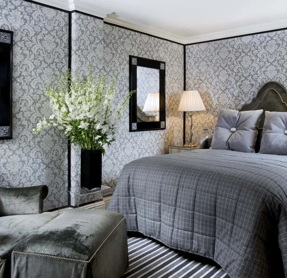 Elegant superior queen room at The Milestone Hotel & Residences, featuring plush bedding, ornate headboard, and refined British interior design touches.