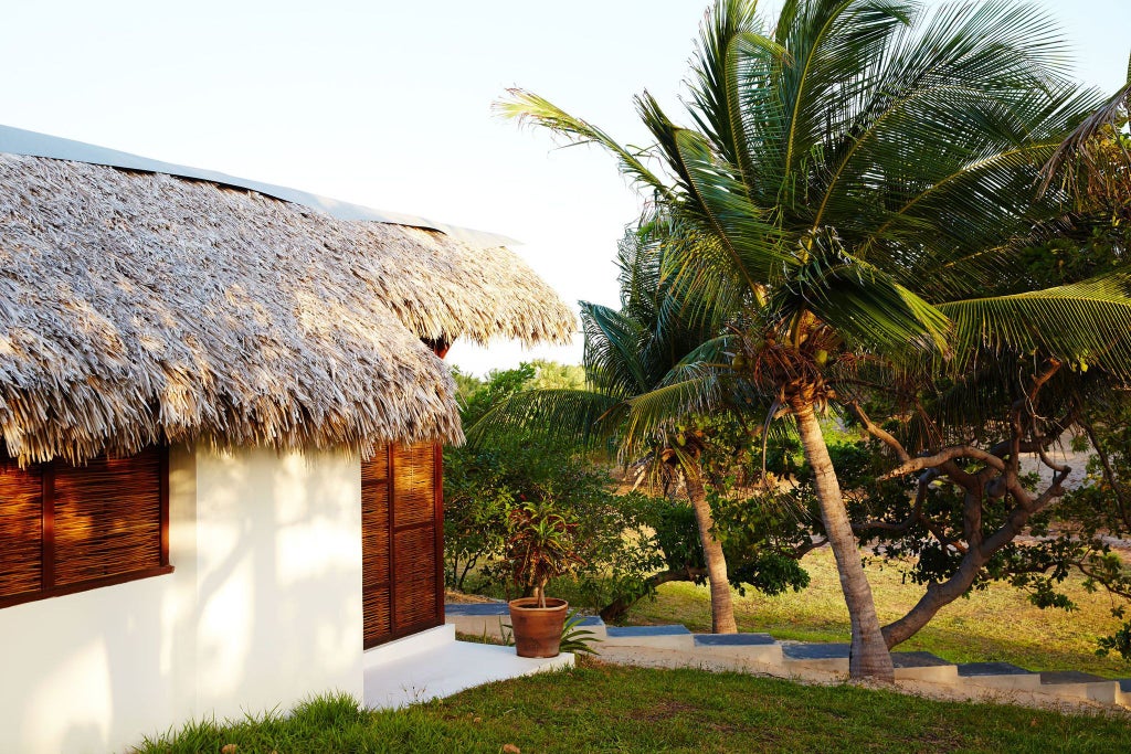 Luxurious garden view lodge at La Ferme de Georges, featuring elegant rustic decor, lush tropical greenery, and serene Brazilian landscape beyond