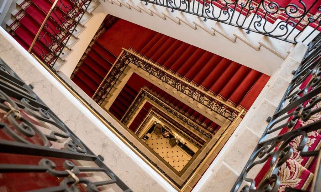 Ornate baroque hallway in Grand Hotel Majestic with crystal chandeliers, gilded mirrors, and plush red carpets leading to elegant suites