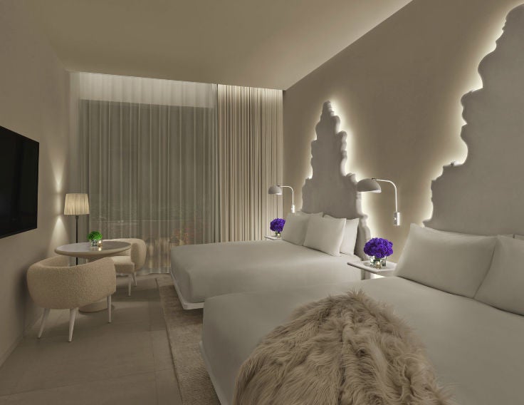 Contemporary hotel room with two queen beds, marble accents, floor-to-ceiling windows, and private balcony overlooking Madrid's skyline.