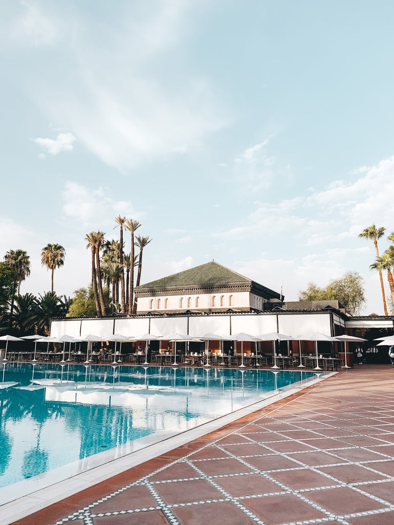 Opulent five-star Moroccan hotel La Mamounia featuring traditional Islamic architecture, lush gardens, and ornate tilework at sunset