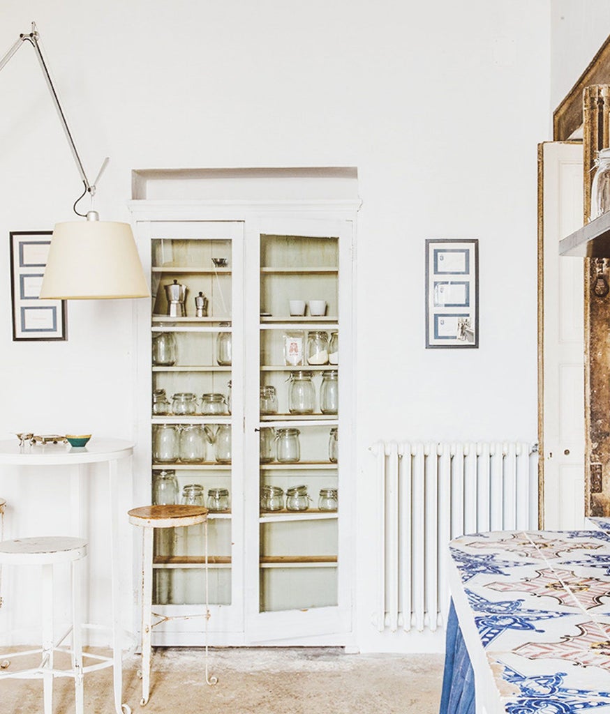 Elegant suite at a historic Italian palazzo with ornate frescoed ceiling, minimalist designer furniture, and warm natural light streaming through tall windows.