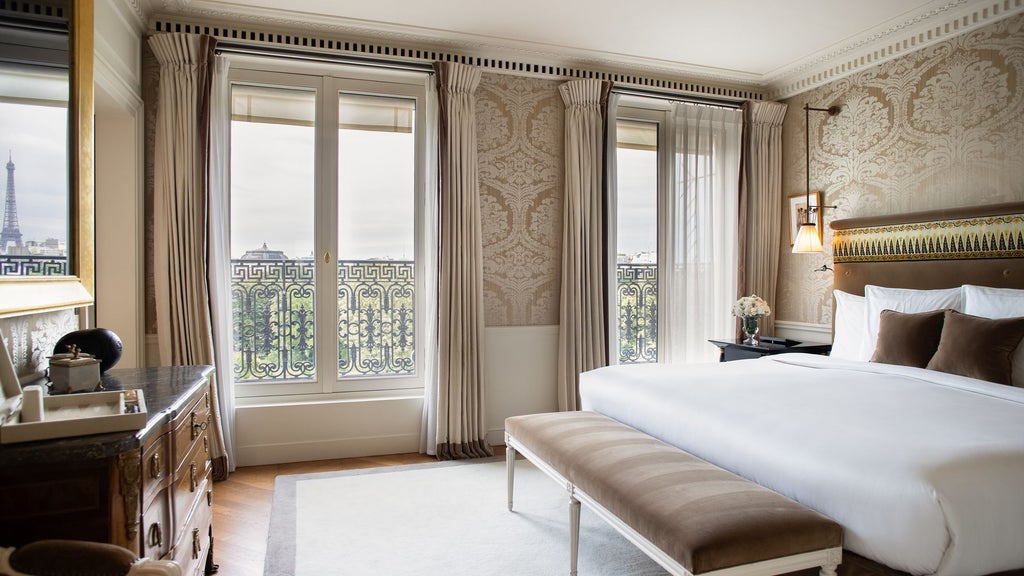 Opulent Parisian hotel suite with sweeping Eiffel Tower views, plush cream-toned furnishings, elegant marble bathroom, and expansive city panorama through floor-to-ceiling windows