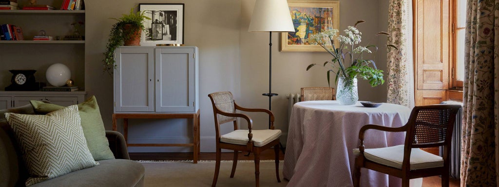 Elegant chamber room at a luxury countryside estate, featuring muted sage green walls, plush white bedding, and soft natural lighting through large windows