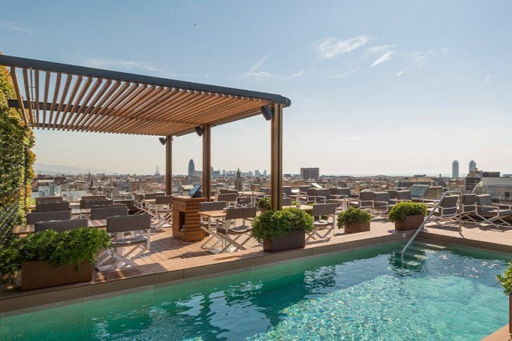 Elegant five-star hotel facade with ornate stone architecture, wrought iron balconies and classical European styling in Barcelona's heart