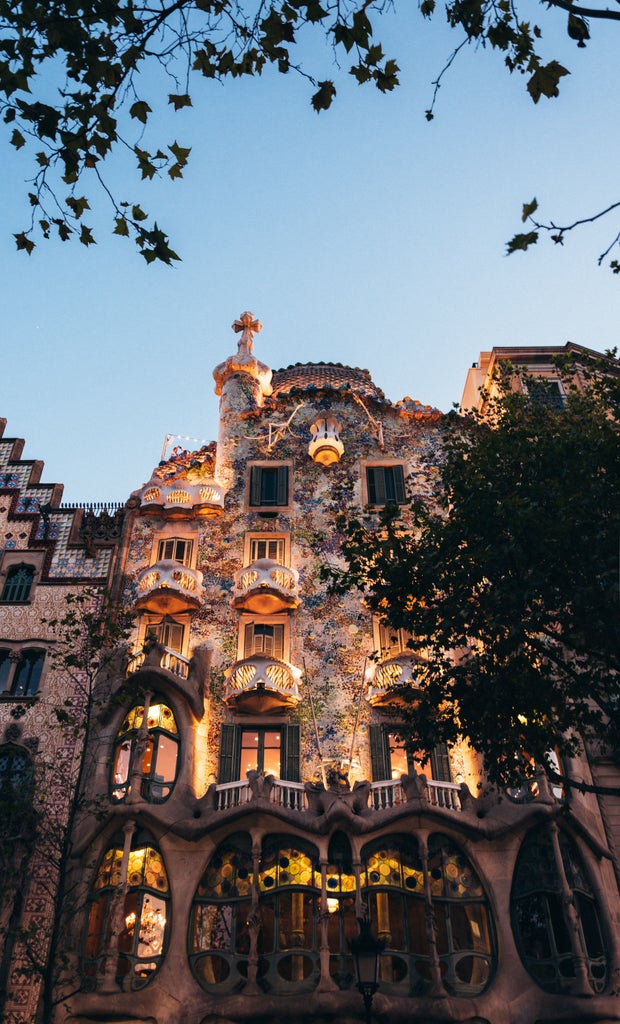 Sunset panorama of Barcelona's Gothic Quarter with golden light illuminating ornate architecture and church spires against a warm sky