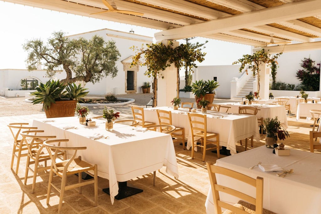 Rustic luxury stone villa with terracotta roof, surrounded by lush olive groves, showcasing traditional Puglian architecture and serene Mediterranean landscape