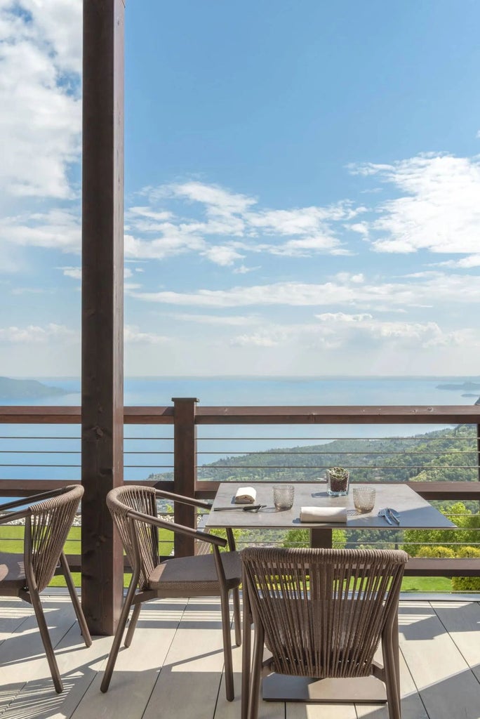 Infinity pool overlooking Lake Garda with elegant loungers, surrounded by lush mountains and modern architectural elements at sunset