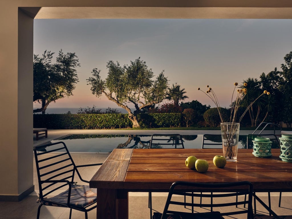 Luxurious whitewashed Greek villa bedroom with panoramic Aegean Sea view, minimalist design, elegant wooden furniture, and sun-drenched terrace