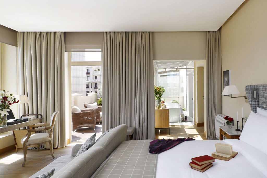 Elegant junior suite with private terrace at URSO Hotel & Spa, featuring modern design, plush furnishings, and warm neutral tones overlooking Madrid's cityscape