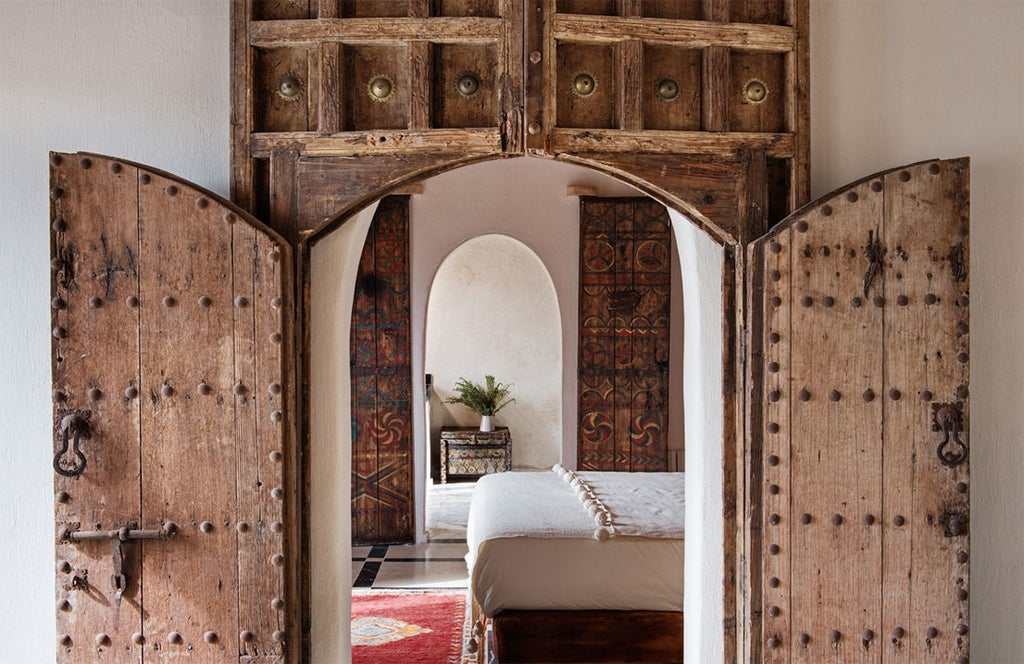 Luxurious Moroccan hotel nestled in Atlas Mountains, featuring traditional kasbah architecture with terracotta walls and panoramic valley views