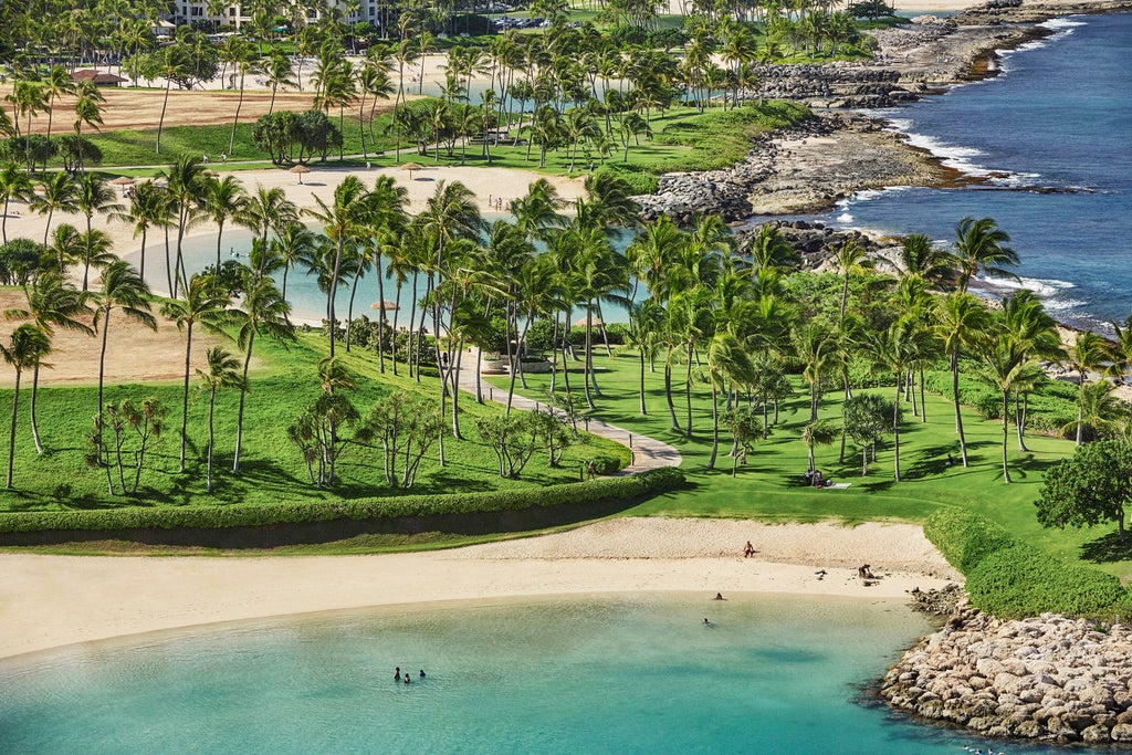 Luxurious beachfront resort featuring infinity pools overlooking the Pacific Ocean with private cabanas and swaying palm trees at sunset