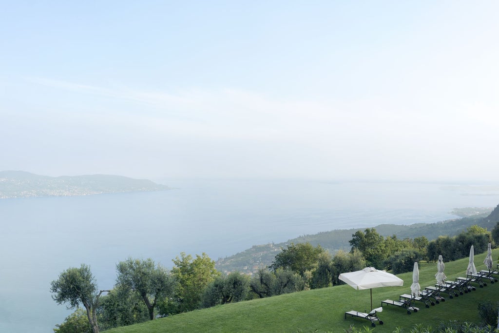 Luxurious cliffside resort with infinity pool overlooking Lake Garda, surrounded by Mediterranean gardens and modern architecture