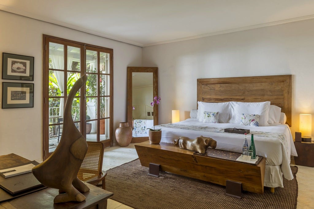 Elegant Brazilian hotel room with plush white bedding, wooden floors, and a private balcony overlooking historic scenset neighborhood in Rio de Janeiro