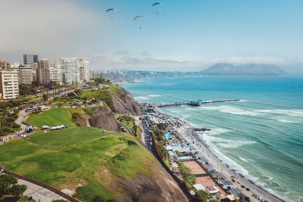 Sunset panorama of Lima's affluent Miraflores district with luxury high-rises along Pacific coast cliffs and manicured gardens