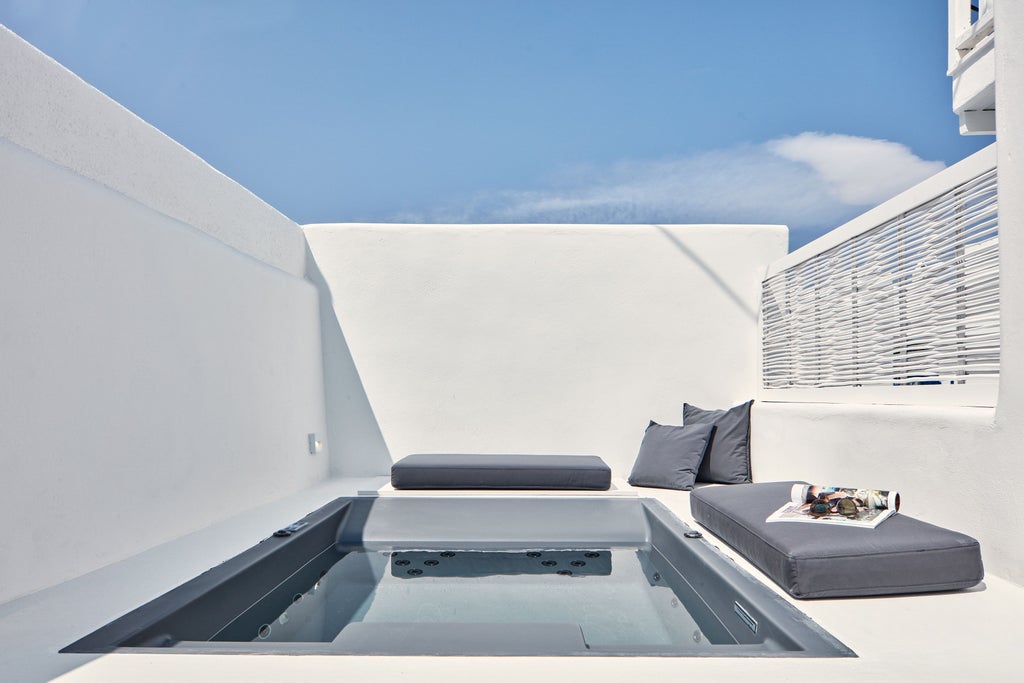 Luxury Boho Suites set against Santorini's white cliffs with private infinity pools overlooking crystalline Aegean Sea and sunset views