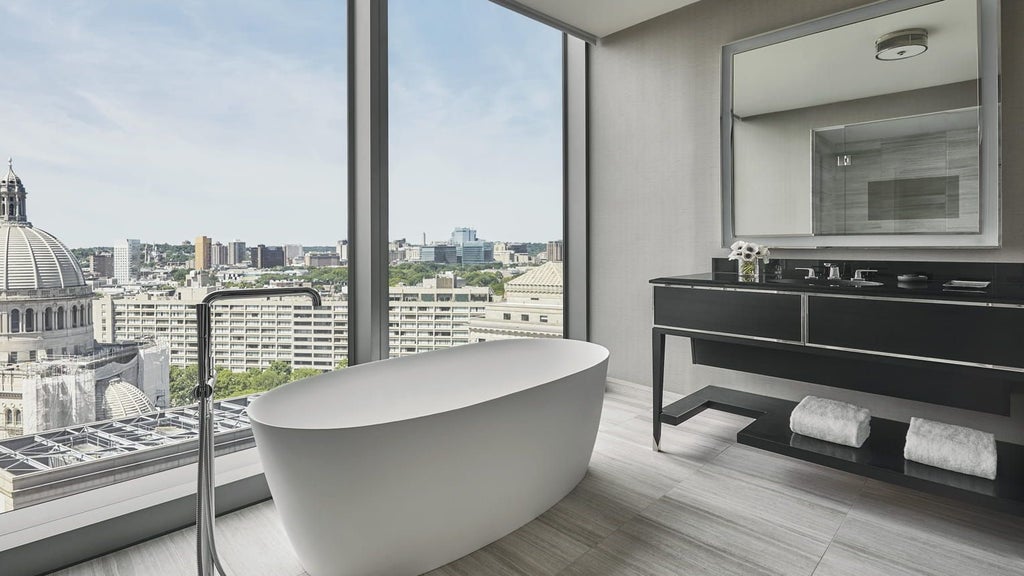 Spacious Four Seasons Hotel Boston corner suite with elegant furnishings, floor-to-ceiling windows, and sophisticated Back Bay architectural views