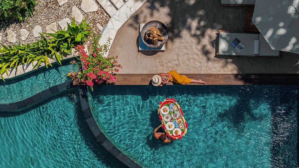 Luxurious wooden treehouse villa perched among lush tropical trees overlooking stunning ocean view at NIHI Sumba resort in Indonesia