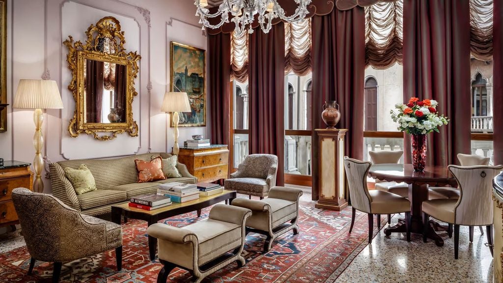 Opulent Venetian suite with crystal chandeliers, ornate gold-framed mirrors, plush period furniture, and high ceilings with fresco details