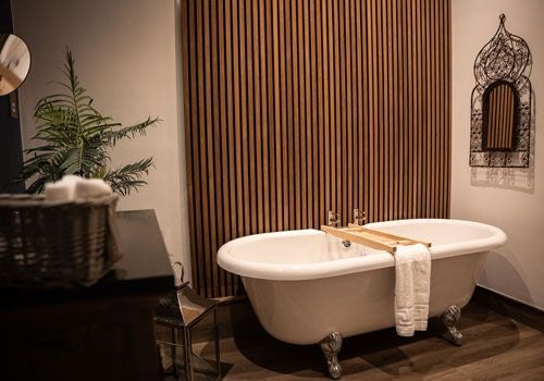 Elegant ensuite bedroom at Yorebridge House with plush white bedding, soft lighting, and luxurious contemporary design in a serene UK countryside setting