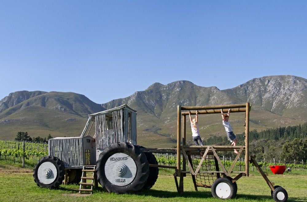 Luxury safari-style tent overlooking rolling vineyards and mountains, with private wooden deck and outdoor seating at Stanford Hills estate