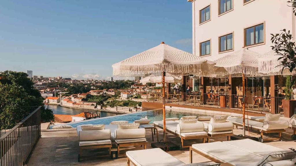 Elegant rooftop terrace of Torel Avantgarde hotel overlooking Porto's Douro River, with modern lounge seating and panoramic city views