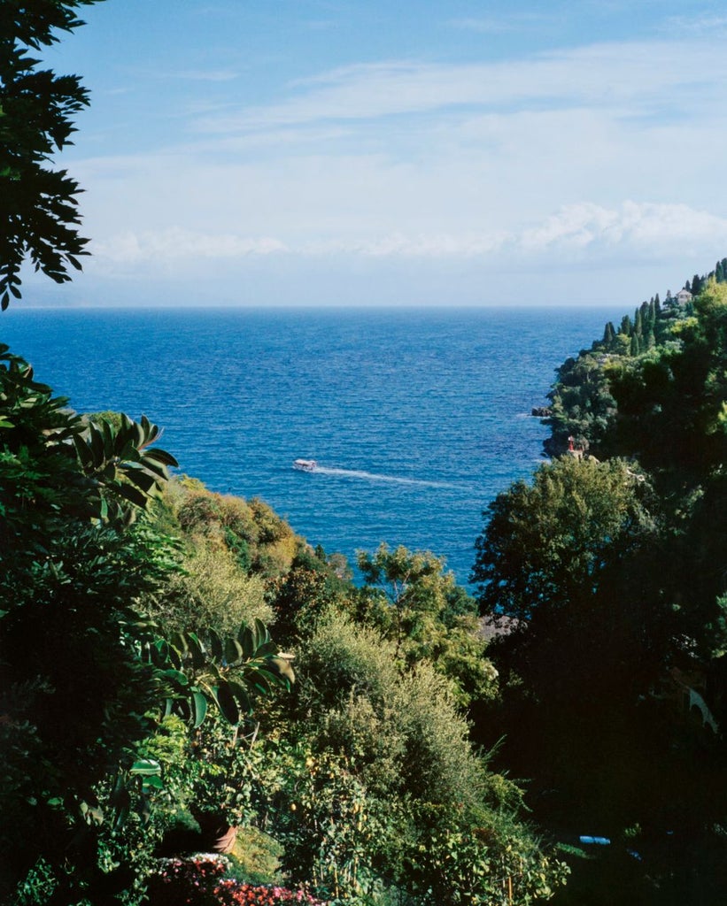 Luxurious cliffside Belmond Splendito hotel overlooking Mediterranean Sea, with infinity pool and terraced gardens against Amalfi sunset