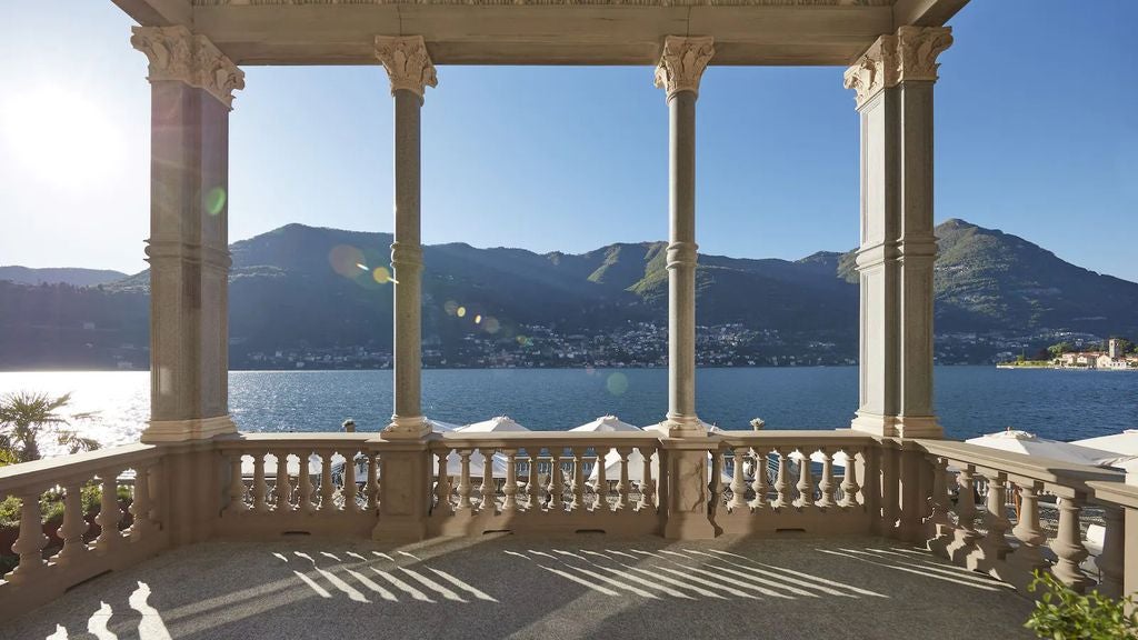 Elegant five-star lakefront hotel with infinity pool overlooking Lake Como, surrounded by manicured gardens and Italian Alps