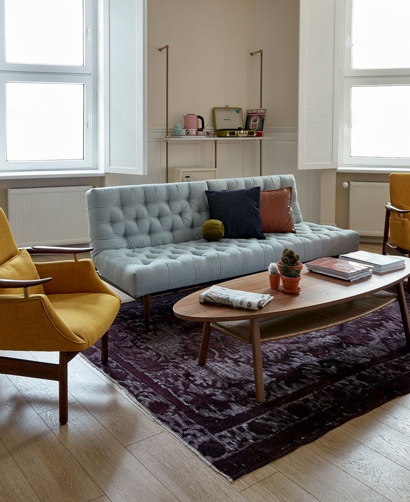 Luxurious hotel room with modern minimalist design, featuring sleek gray furnishings, large bed with crisp white linens, and contemporary urban aesthetic