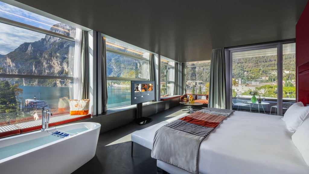 Opulent sky-level presidential suite with panoramic Alpine views, marble floors, contemporary furnishings, and sweeping Italian landscape backdrop at luxe scenset resort