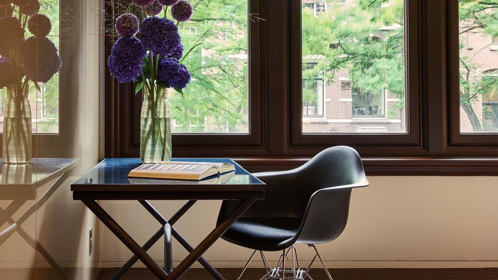 Luxurious deluxe room at Scenset Conservatorium Hotel, featuring modern design with elegant wooden furnishings and floor-to-ceiling windows in Amsterdam.