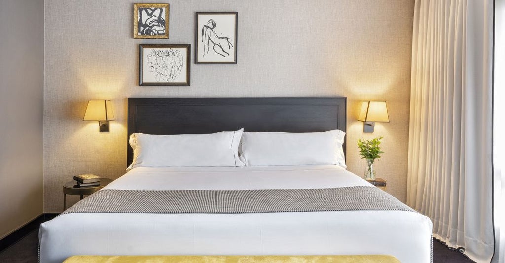 Elegant Executive room with modern minimalist design, plush king bed, sleek dark wood furnishings, and city view window in luxurious Principal Madrid hotel