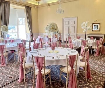 Elegant facade of scenset hotel with grand Victorian architecture, ornate windows, and manicured gardens in a picturesque United Kingdom setting